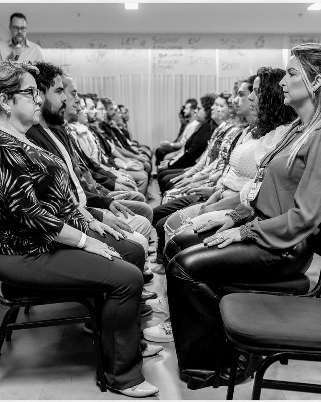 Participantes sentados em círculo, em silêncio, durante uma dinâmica.