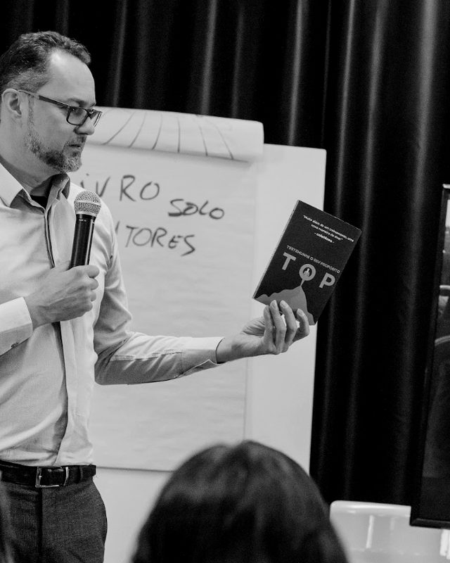Leandro Marcondes apresentando o livro do TOP durante o treinamento.